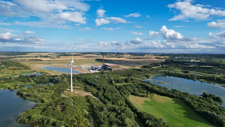 White Turbine On Green Grass Field Near Water Ponds