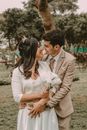 Man in Brown Suit Kissing Woman in White Dress