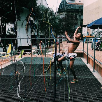 Children enjoying a festive dance with ribbons in a vibrant São Paulo city square.