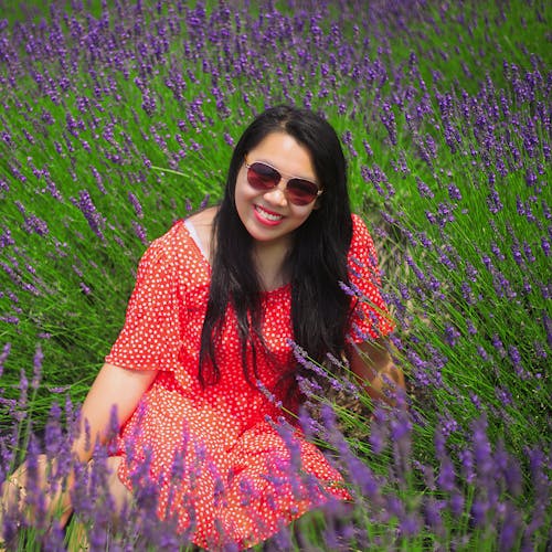 Free Woman in a Polka Dot Dress Sitting on a Lavender Field Stock Photo