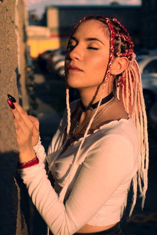 Selective Focus Photo of a Woman with Braided Hair Closing Her Eyes