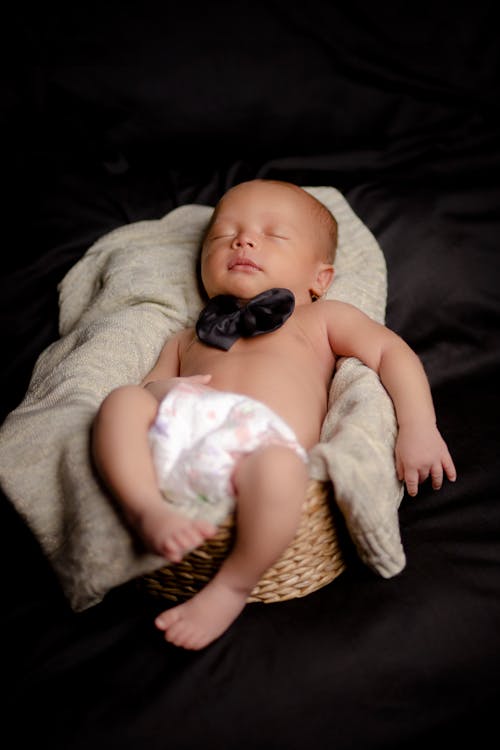 Newborn Baby on a Wicker Basket with Cushy Fabric
