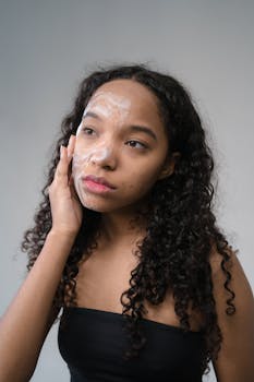 Close-up of a young woman applying skincare cream for self-care and healthy skin.