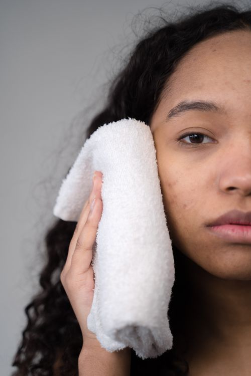 Free A woman gently presses a soft face towel against her cheek in a skincare routine. Stock Photo