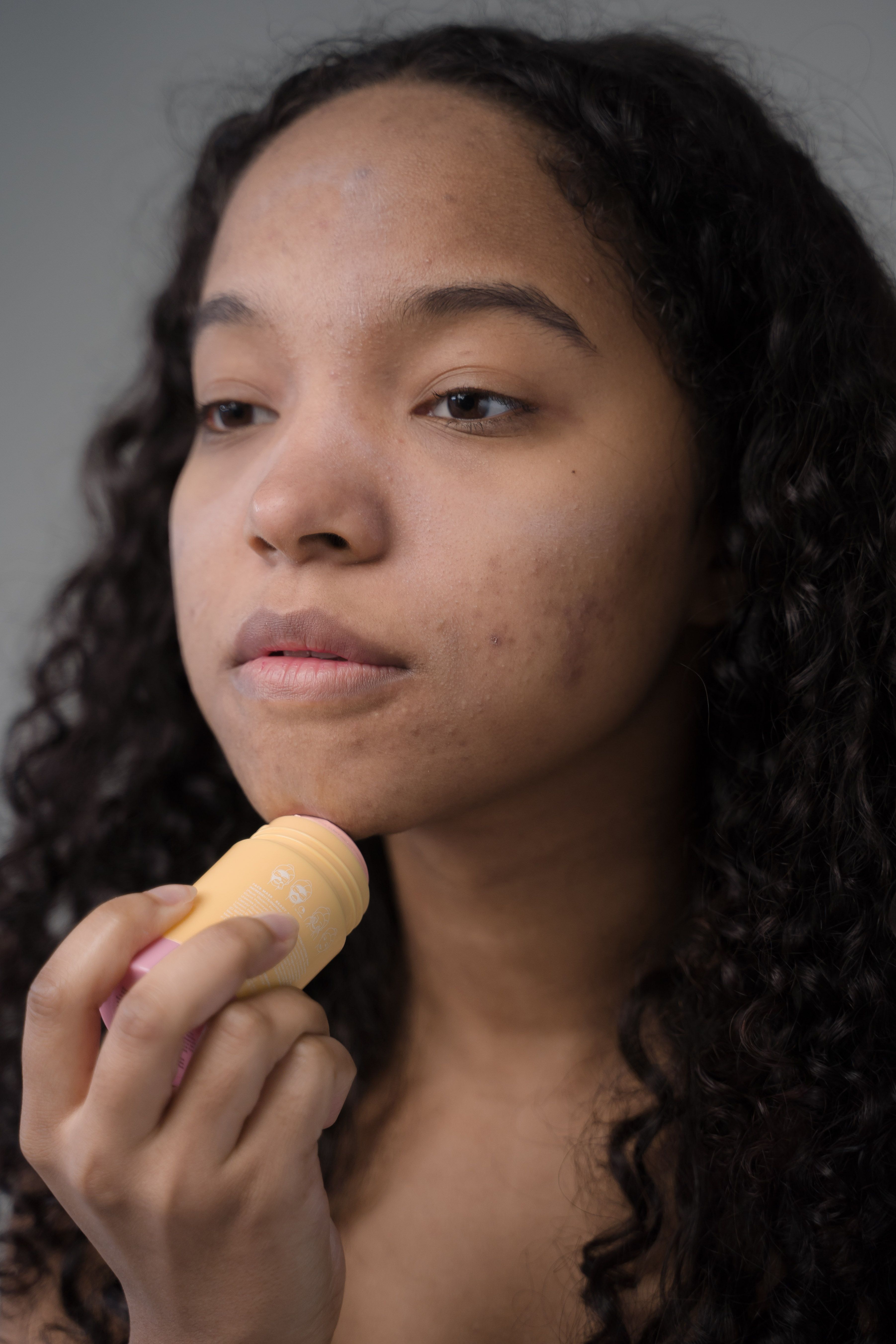 Young woman applying skincare product in a routine for healthy skin care.