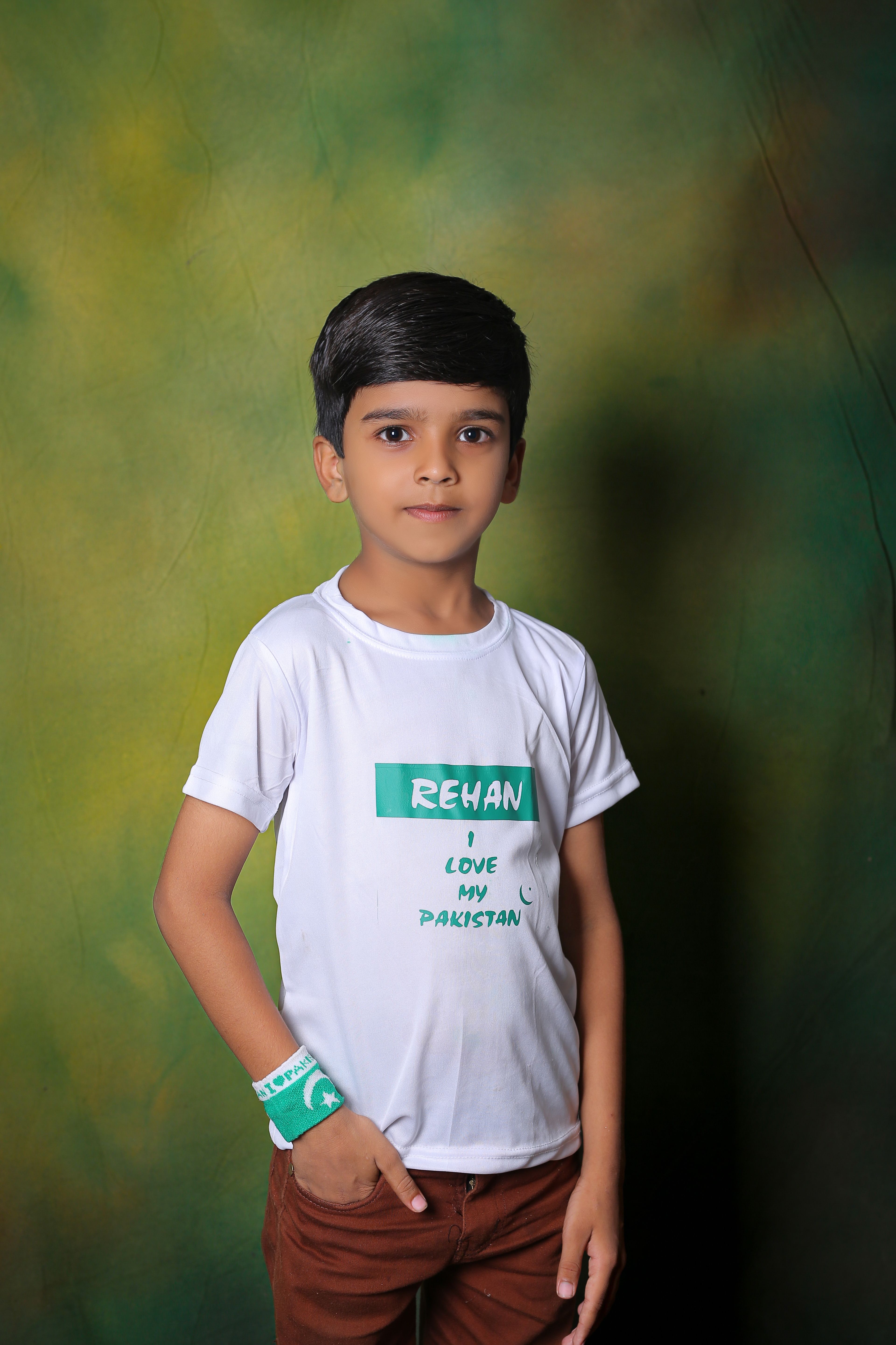 Child wearing a patriotic shirt in Pakistan studio portrait.