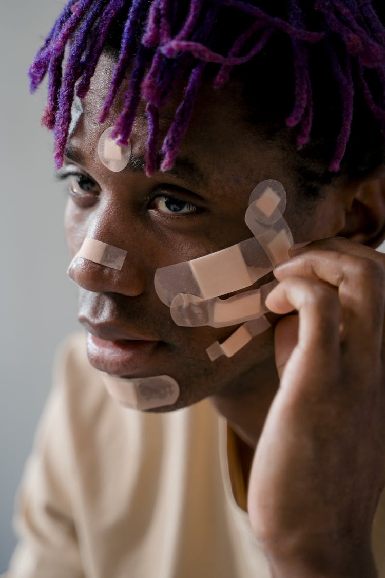 Portrait Of A Man With Band Aids On His Face