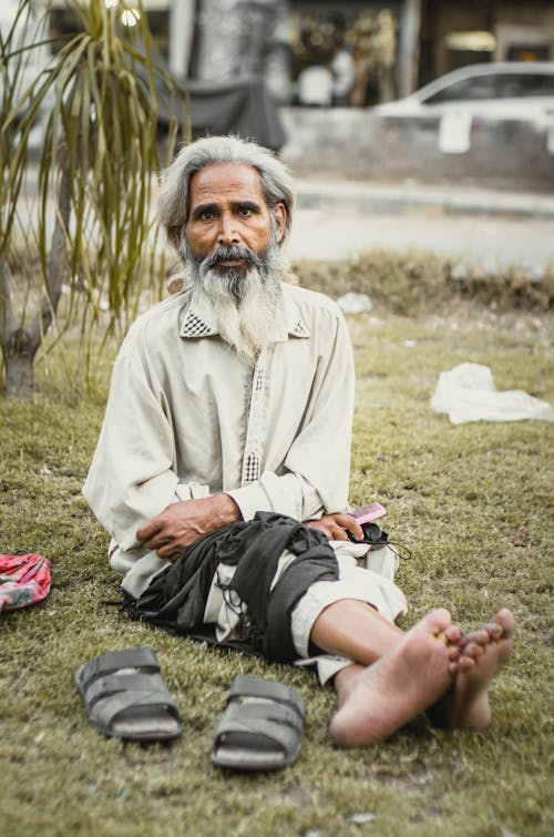 An Elderly Man Sitting on the Grass