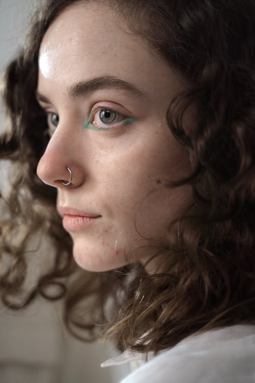 Close Up Photo of Woman With Green Eyeliner Wearing Nose Ring