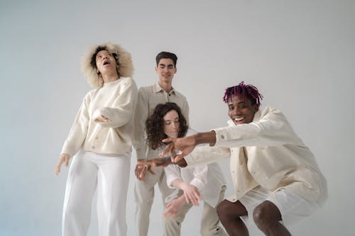 Group of Men and Women in Beige and White Outfits Having Fun