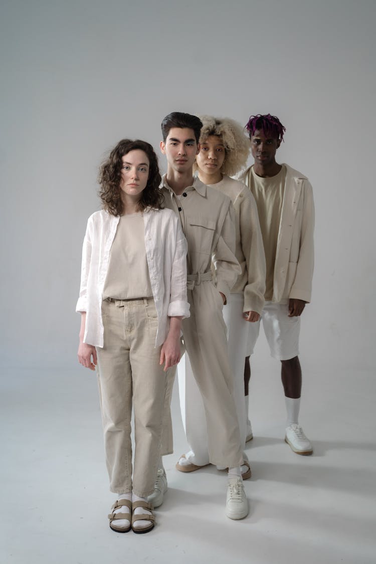 Men And Women In Beige And White Outfits Standing In Line