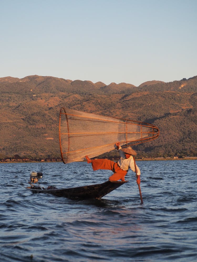 Fisherman With Net On Boat