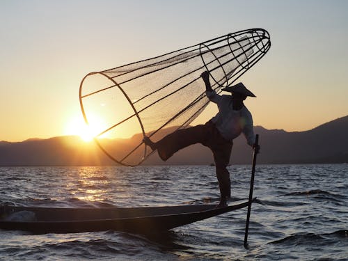 Free Silhouette of a Person Fishing during Sunset Stock Photo