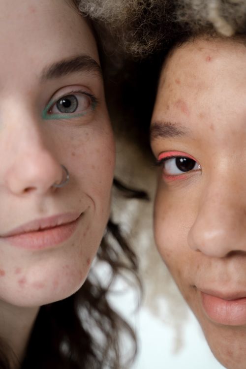 Free Intimate close-up of two women expressing diversity and beauty with unique eye makeup. Stock Photo
