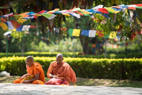 Free Two Monks Wearing Orange Robes Sitting Stock Photo