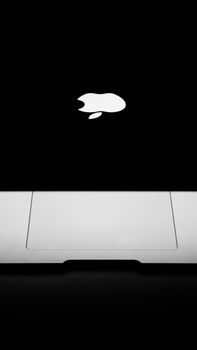 Elegant close-up of a MacBook featuring the iconic Apple logo on a black background. 9257744