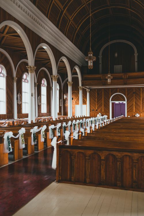 Free Beautifully decorated church interior featuring wooden pews, arches, and a warm ambiance for a serene setting. Stock Photo