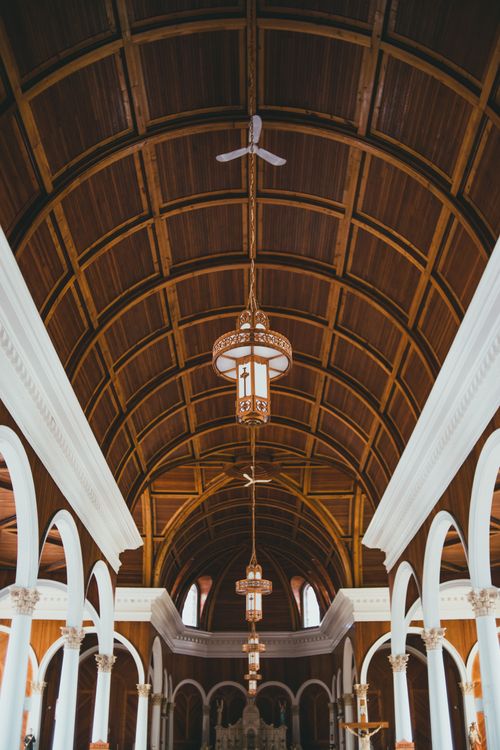 Free Beautiful interior of a church featuring a wooden arched ceiling and ornate chandeliers. Stock Photo