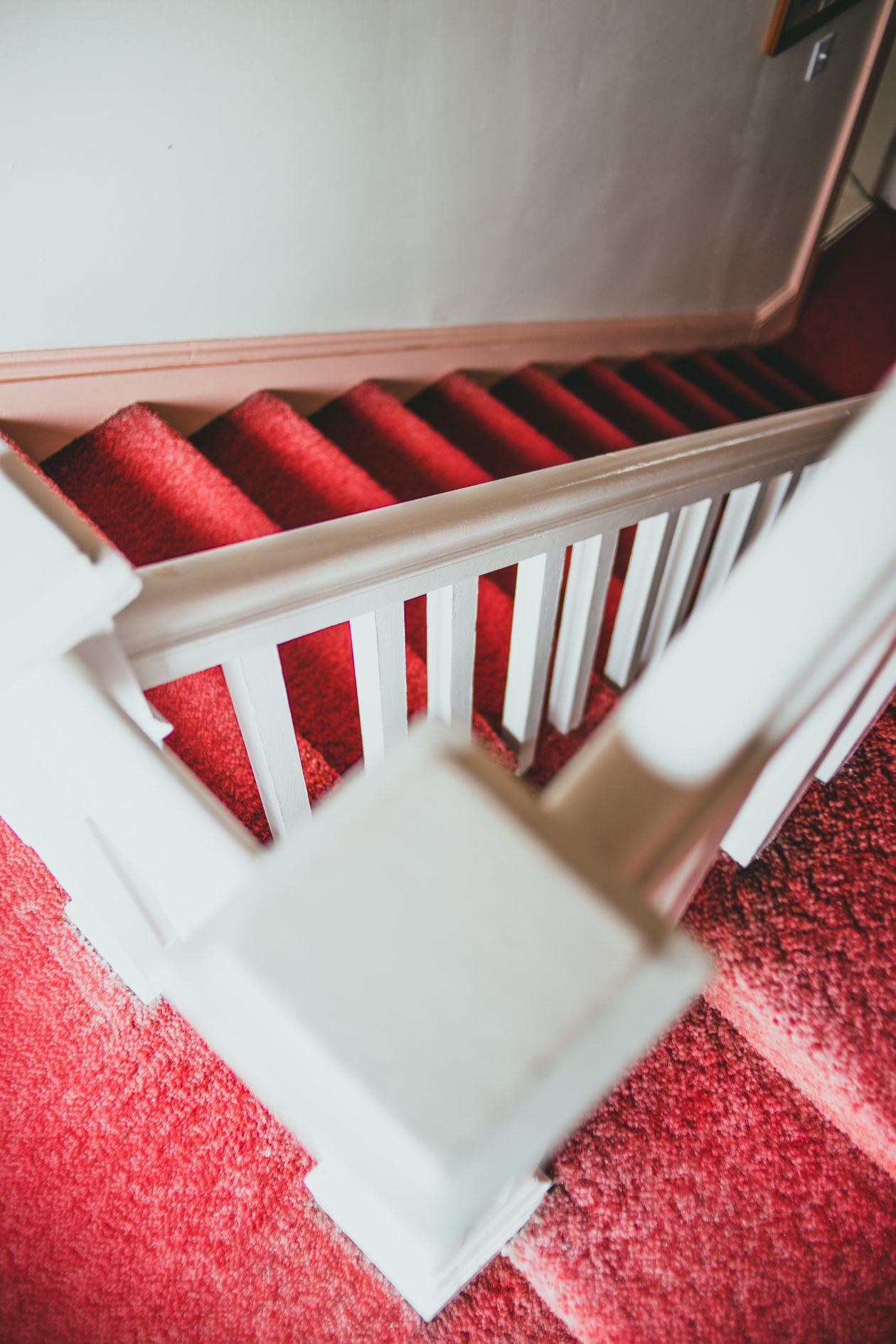 Staircase with a bright red carpet representing moving up a waitlist toward VIP early access