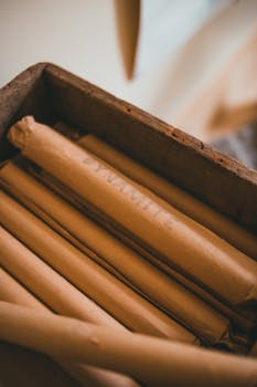 Close-up of a wooden box containing rolls of craft paper with a rustic aesthetic.