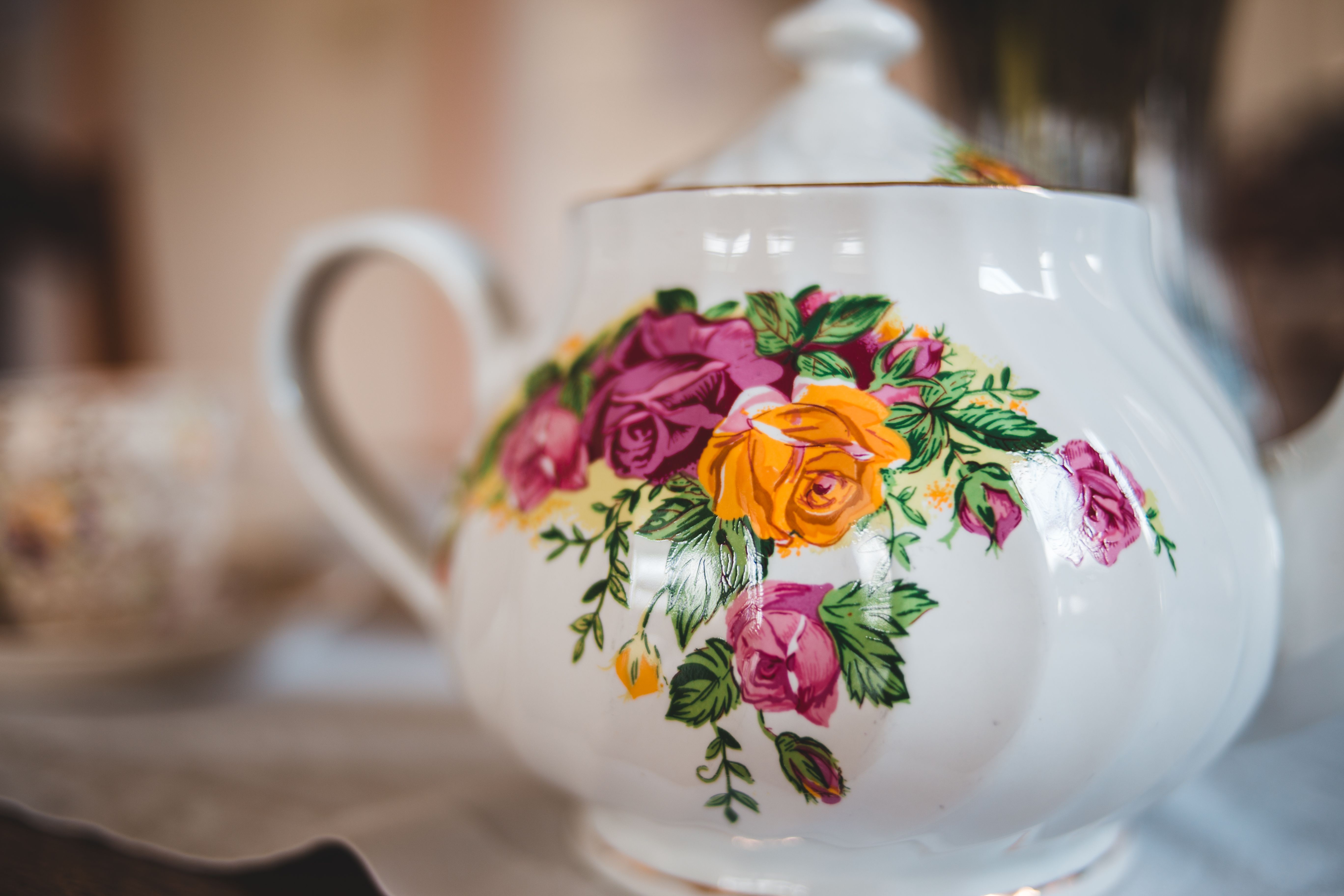 Close-up of an ornate teapot with vibrant floral patterns, showcasing its elegant ceramic craftsmanship.