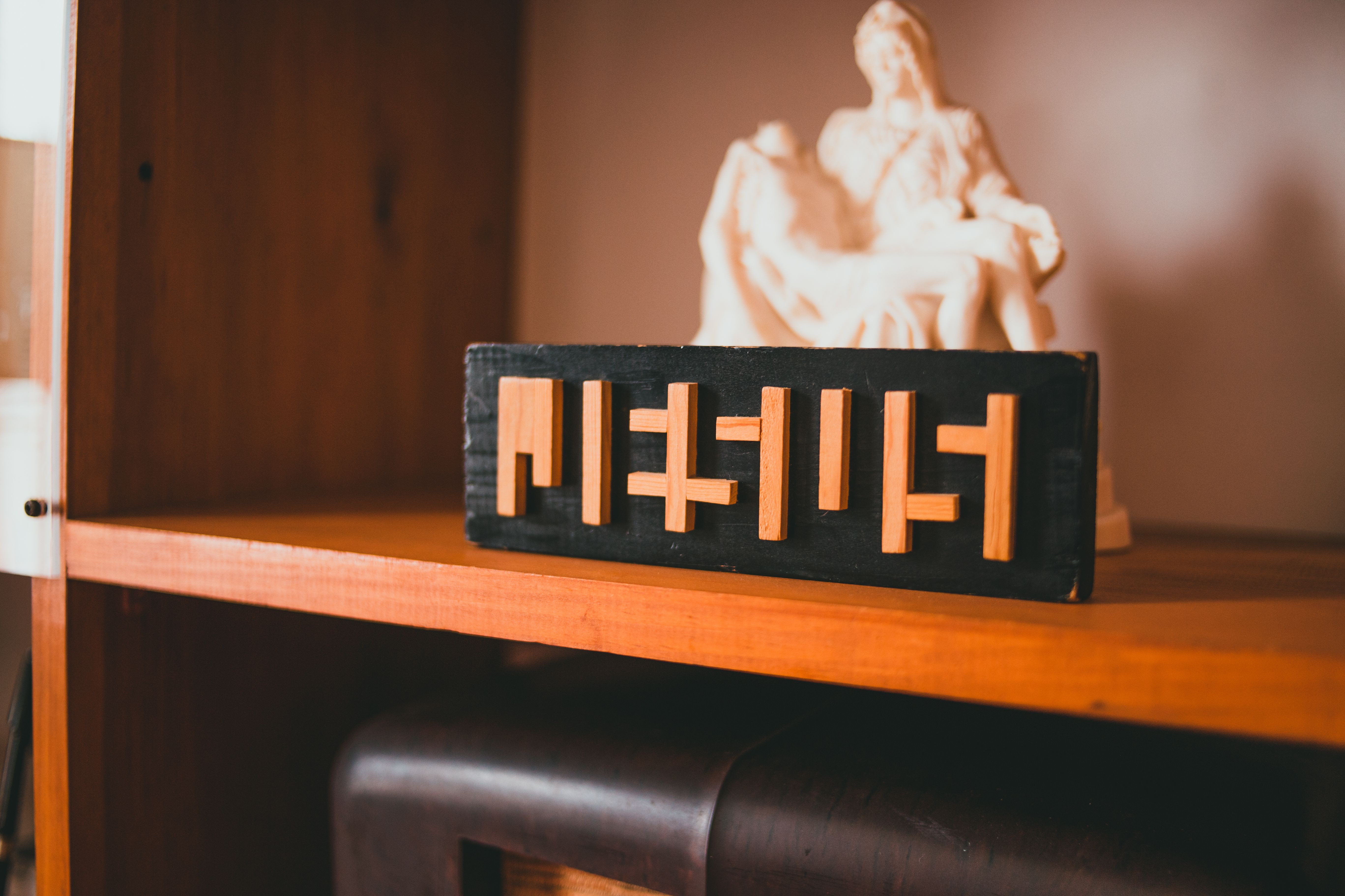 A wooden shelf adorned with a religious statue and wooden Jesus block, adding faith-inspired decor to the interior.