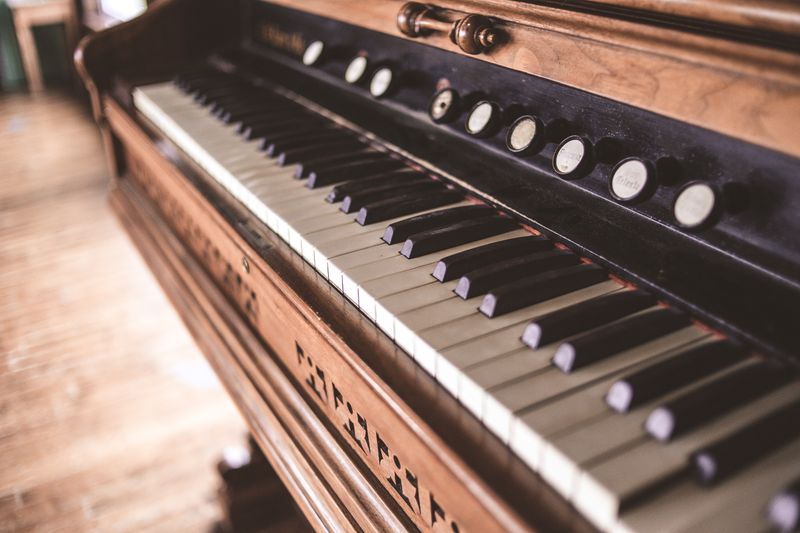 Close-up of antique piano keys with a vintage look, showcasing classic craftsmanship in selective focus.