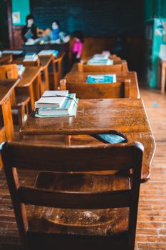 A nostalgic view of a vintage classroom with wooden desks and classic textbooks.