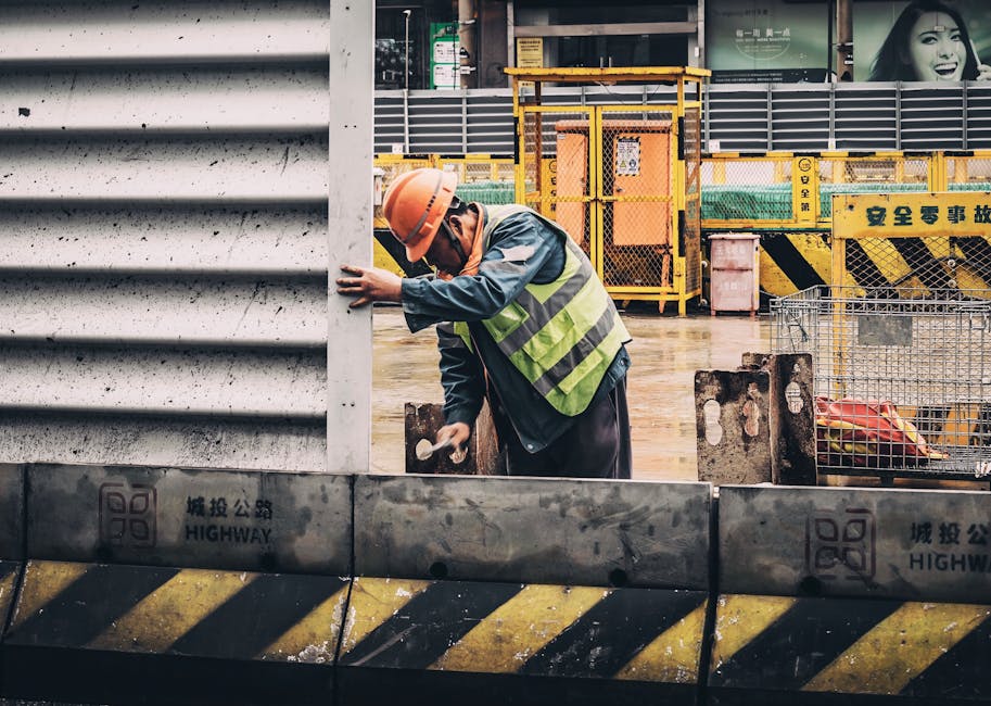 A construction worker wearing full safety gear including hard hat, safety vest, and protective equipment - Austin construction injury lawyer