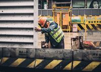 Worker in orange hard hat and reflective vest on a construction site