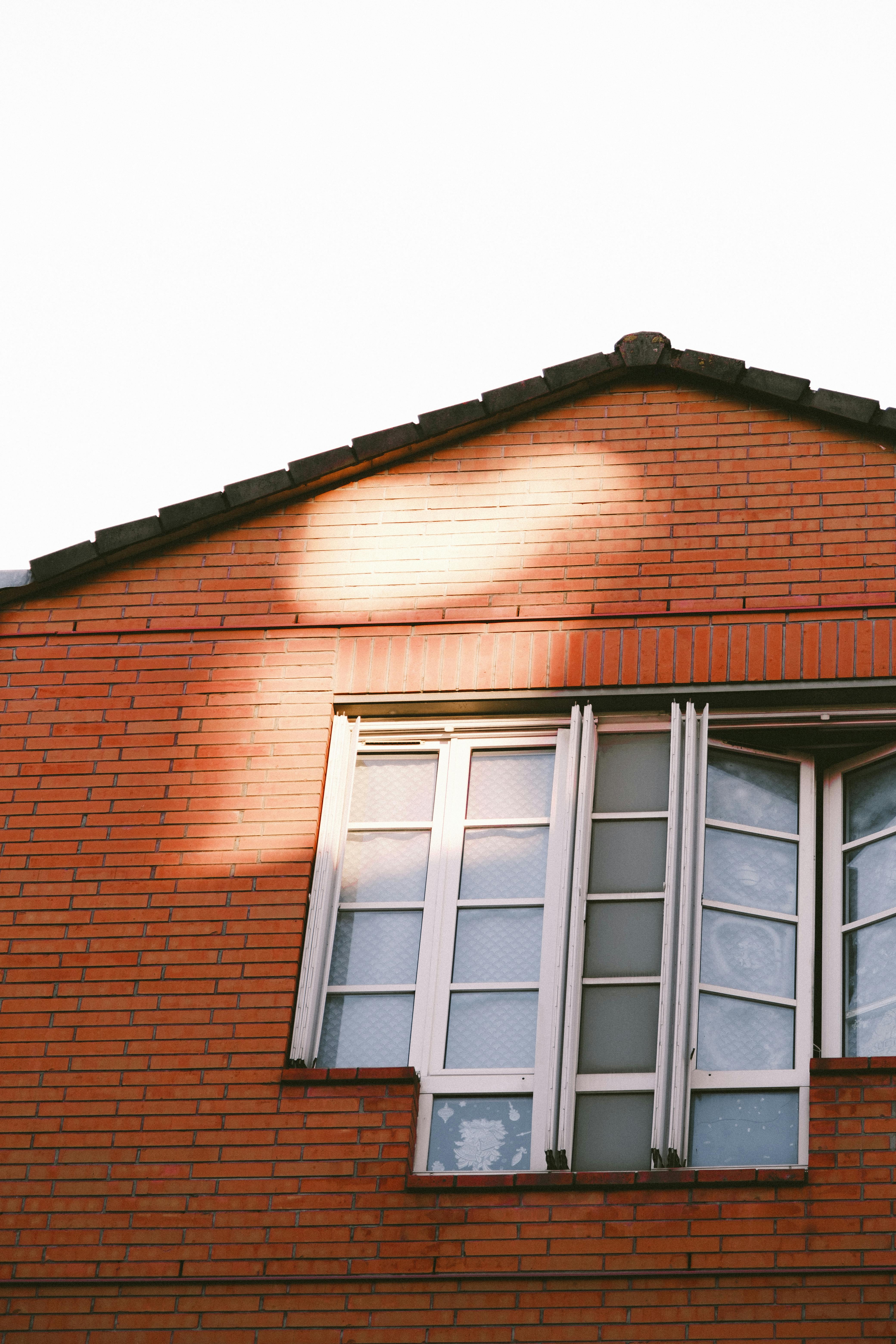 Facade of an unfinished two-story house with no red brick windows