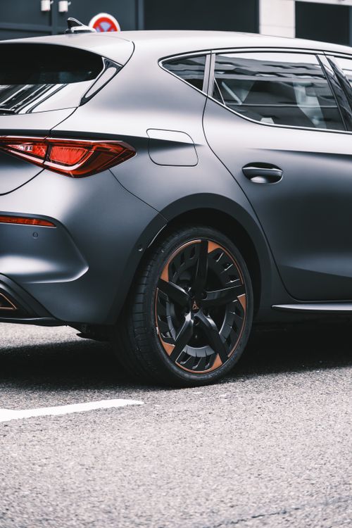 Free Close-up of a sleek car parked on a city street, showcasing modern design and taillight details. Stock Photo