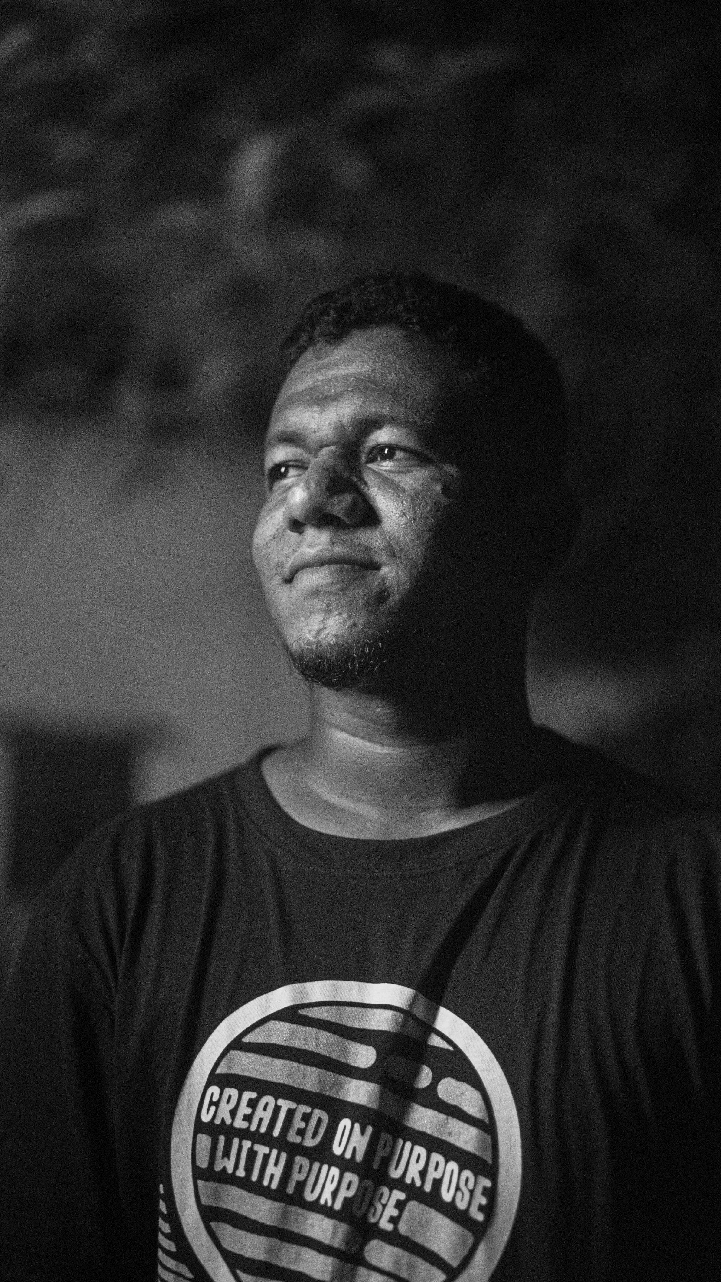 Grayscale close-up portrait of a confident young man at night.
