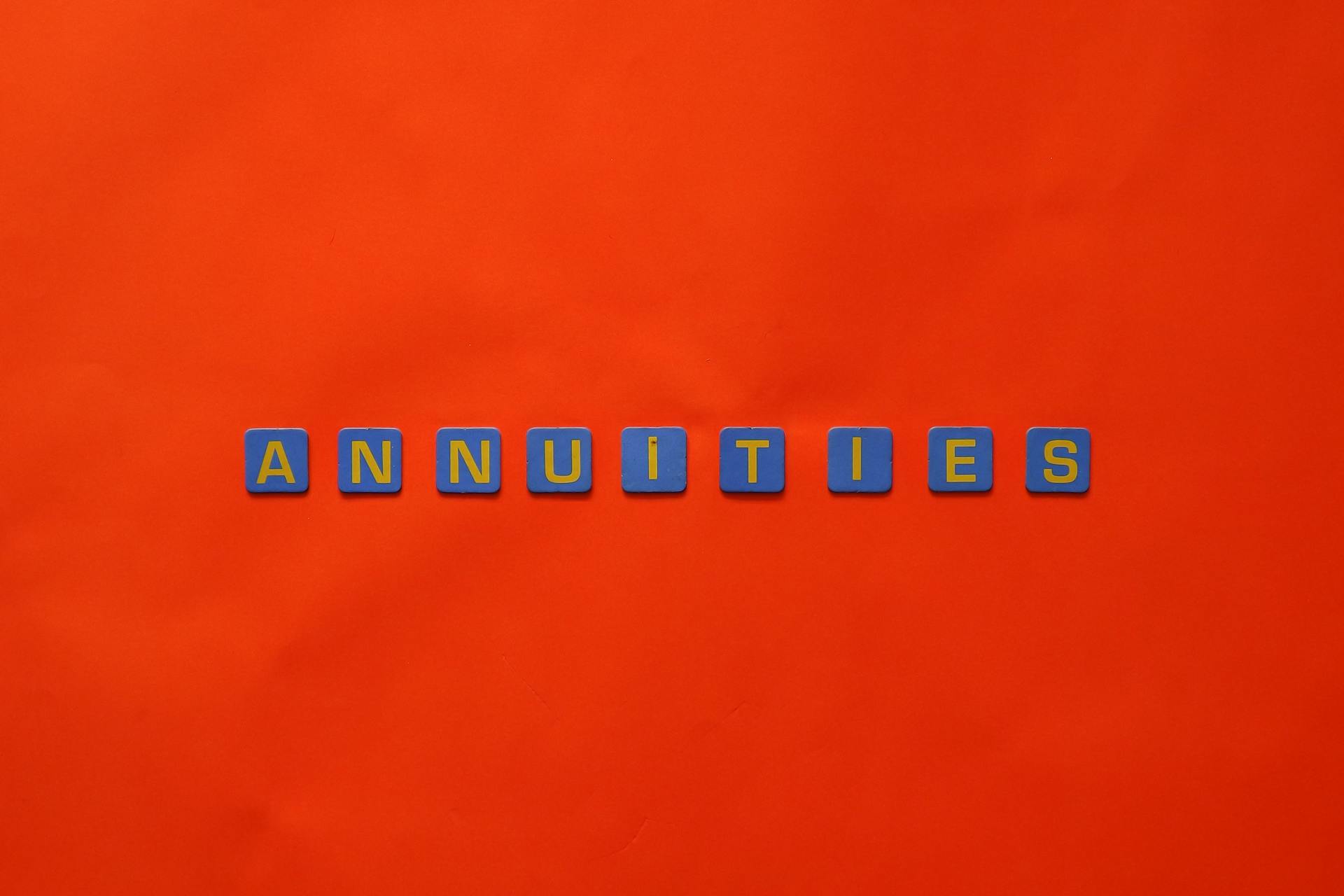 Conceptual image of the word 'Annuities' spelled with tiles on a vibrant red background.