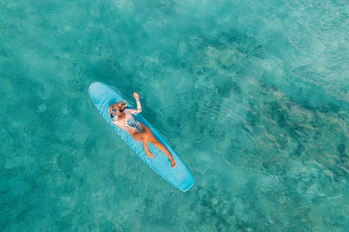 A Woman Lying on a Surfboard