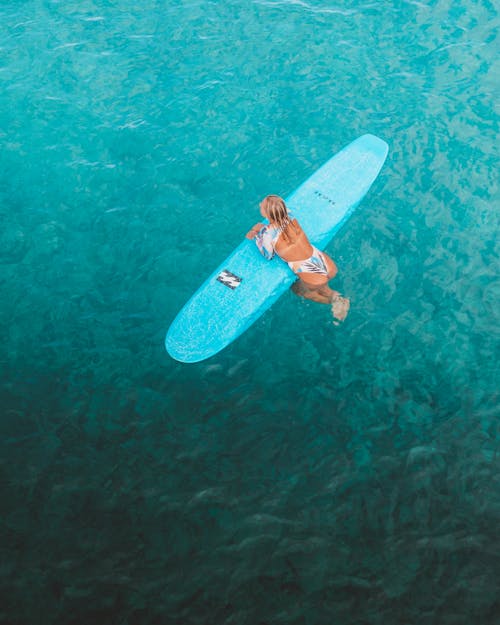 A Woman with a Surfboard in Sea