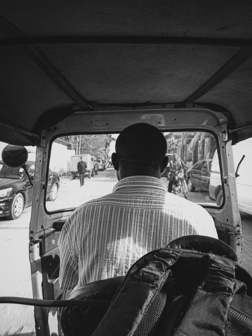 Free Black and white photo of a scooter driver navigating a bustling city street. Stock Photo