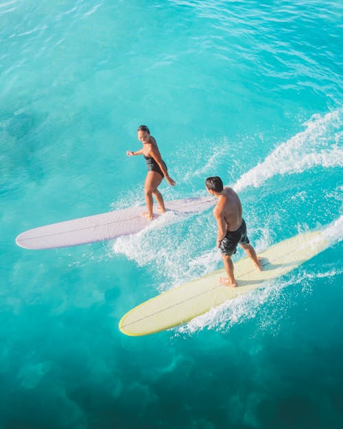 Drone Shot of a Man and a Woman Surfing
