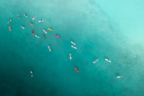 Drone Shot of People Surfing in Turquoise Water 
