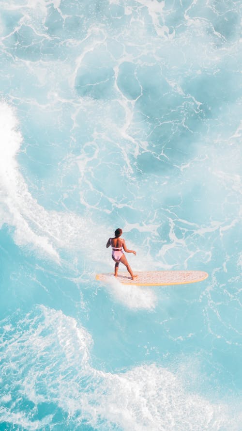 Pastel Blue Rough Water and Woman on a Surfboard
