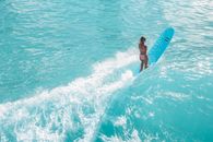 A Woman in a Bikini Surfing