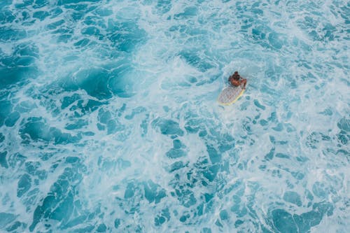 Woman on Surfboard among Waves