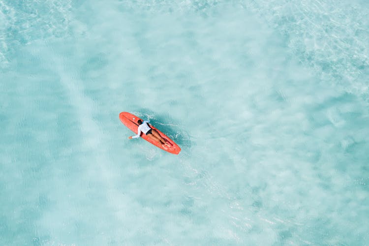 Surfer Lying On Surfboard In Sea