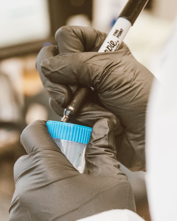 Chemist Signing Sample In Laboratory