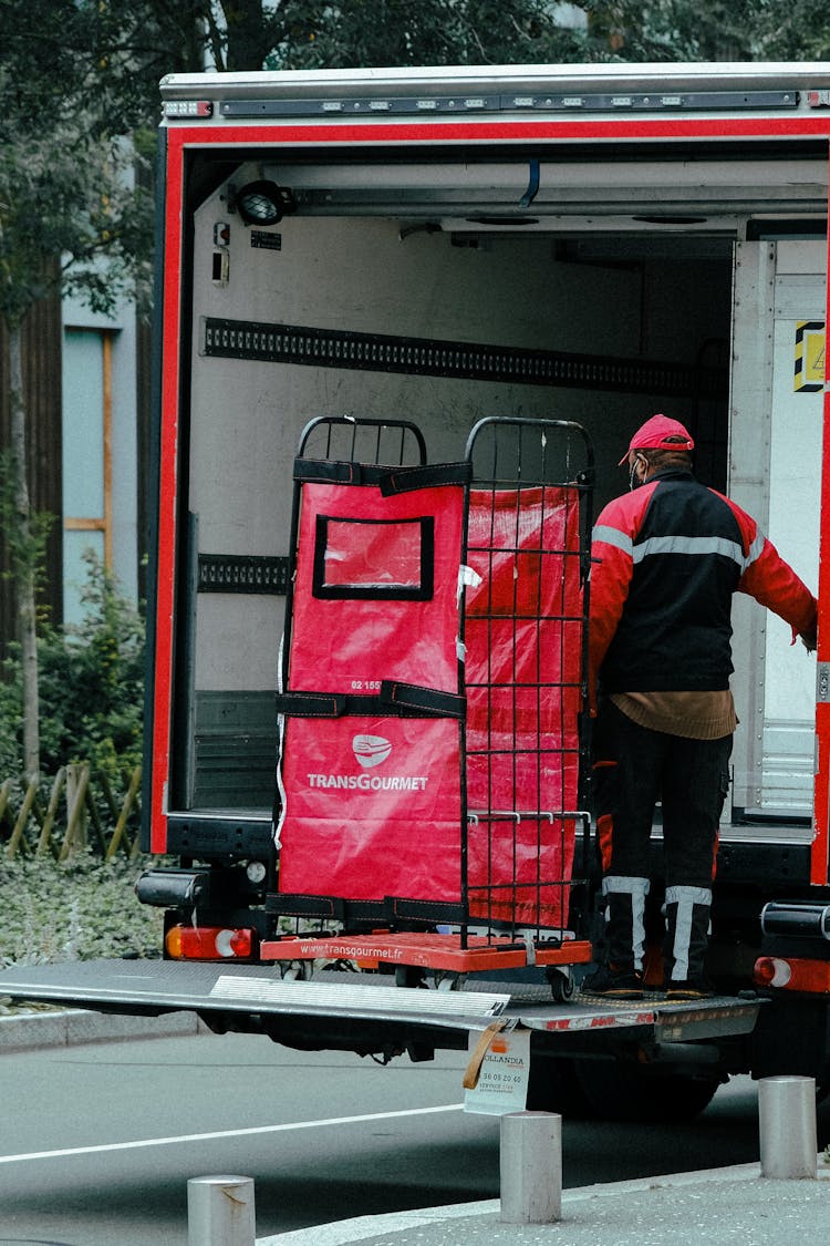 Delivery Man On A Platform On The Back Of His Truck 