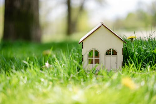 Close-Up Shot of a Miniature House on the Grass