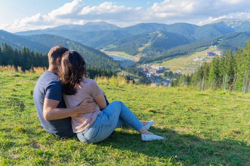Free A Romantic Couple Sitting on top of the Mountain Stock Photo