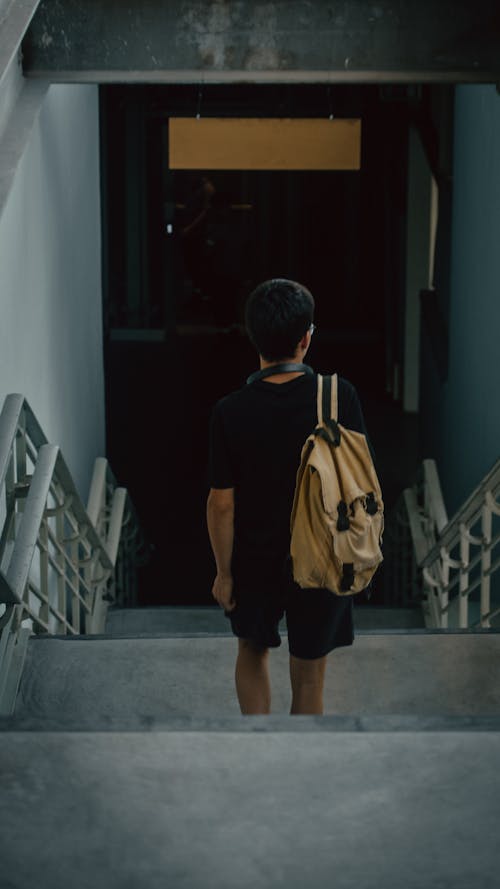 Man in Backpack Going Down the Concrete Stairs