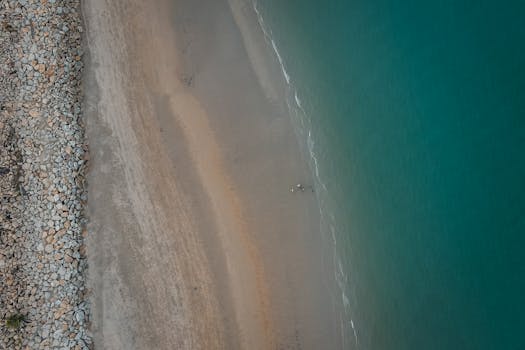 Serene aerial photo of a beach coastline in Chukai, Terengganu with turquoise waters and sandy shore.