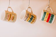 Close-Up Photo of Hanging Ceramic Mugs